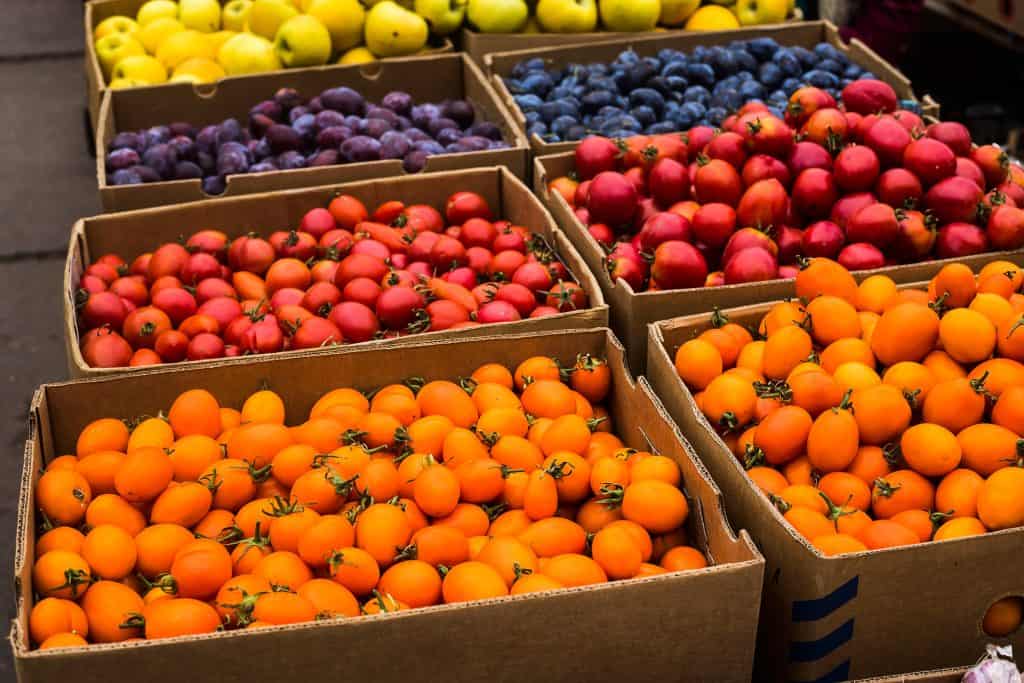 Small organic yellow and red tomatoes on the market in large boxes. Autumn Harvest Concept