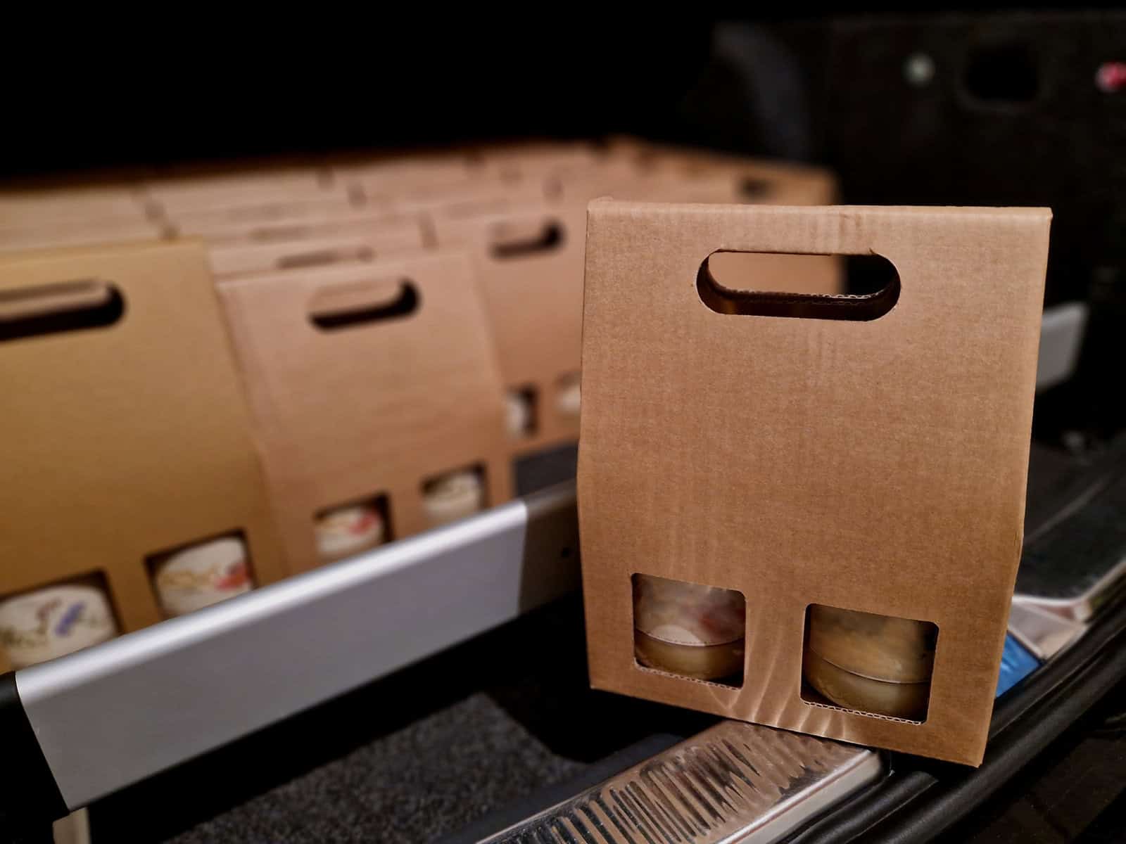 business manager's car storage space. car trunk full of gifts from clients and business partners. employees delivering carton boxes with wine and snacks.
